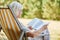 Old pensioner reading in summer