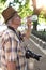 Old pensioner tourist man drinking water in park