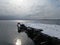 Old pier covered with snow in the Gulf of the Pacific ocean.