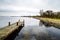 Old pier on the Lake Veere surrounded by greenery under the cloudy sky in the Netherlands