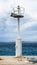 Old pier with a lighthouse beacon and calm sea.