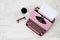 Old pink typewriter from the 1950s with blank paper, coffee and glasses on white painted rustic wood, copy space, high angle view