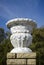 Old plaster garden vase on a modern brick pedestal