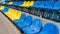 Old plastic chairs blue and yellow in the stadium or playground. Places for spectators of sports competitions