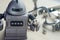 An old plastic robot toy holding a small screw, metal scrap junk on the blurred background.