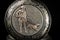 Old pocket watch on a black reflective surface, closed lid with hunting motive