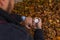 Old Pocket watch in man`s hand and smart watch on the wrist against the background of autumn dried brown leaves