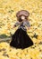 Old porcelain doll on ginkgo leave background