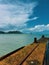 Old port new zealand mahia Beach blue day sun hot water ocean wave concrete sky clouds hill over deactivated ship transport trail