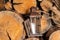 An old portable lantern stands in a rustic wood-burning room.