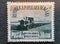 Old postage stamp from Romania circa 1959 shows a tractor plow the field