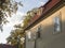 Old prague baroque house at Kampa with open window in golden hour light, trees and sky background