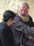 Old priest with a women in the entrance  of the orthodox monastery of Gelati in Georgia.