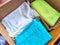 Old rags and eco-friendly cleaning cloths neatly arranged in a cardboard box. Old rags and things for cleaning and