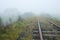 Old railroad and house vanishing in fog