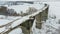 Old railway aqueduct, stone bridge. snow, winter time. aerial, copter shoot