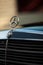 Old rare vintage green Mercedes-Benz hood, badge, radiator grille on blurred background. Editorial use only.