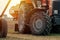 Old red agricultural tractor with trailer on dirt countryside road