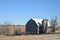 Old red barn with silo on a farm in late autumn on a sunny day