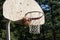 Old red basketball hoop in front of forest