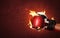 Old red boxing gloves on hot sparkles background with extreme fire flame and fighting fiercely hand for winner or success concept