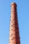 Old red brick chimney against the sky