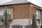 Old red brick house, installed plastic Windows and satellite TV antenna. dilapidated building