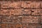 Old red brick wall with cracks and scratches. Horizontal wide brickwall background. broken bricks texture. House facade