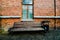 Old red brick wall and old wood window and wood bench background vintage tone.