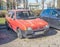 Old red compact car Fiat Uno four doors parked