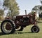 Old red country Tractor on picturesque landscape.