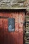 Old red door on surrounded by Devon stone, United Kingdom