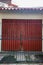 old red garage with black fence in the morning with clear blue sky in a house in bandung city, west java, indonesia