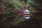 Old red japanese pagoda in the garden lake as birdhouse