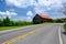 Old red roof barn near highway