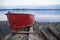 Old red rowboat lying at shore