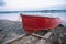 Old red rowboat lying at shore