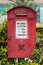 Old red royal mail letter box with queen Victoria monogram