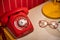 Old red telephone with rotary dial on the table with old glasses