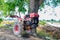 The old red tiller tractor or walking tractor parked under the tree in the fields at countryside, Thailand