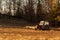 Old red tractor on the edge of a forest. Work in forest. An abandoned tractor. Landscape of the Czech countryside