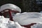 Old red tractor trapped under the snowdrift in the in forest of Rodopi mountain