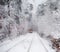 Old red tram, leaving the distance through the snow-covered forest. Selective focus