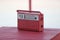 Old red vintage radio on a red table, some interior artwork. Lithuania, Nida