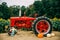 Old red vintage tractor in a sunflower field