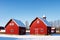 Old red wooden barns of a farm in Sweden under a clear blue sky in winter. made with Generative AI