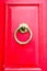 Old red wooden door with round vintage bronze door handle, Mgarr, Malta