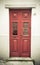 Old red wooden door with window and grid. Toned