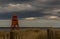 The old, red, wooden Herd Groyne Lighthouse in South Shields, stands out against the cloudy sky