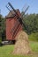 Old red wooden windmill with a haystack in the foreground. Finnish agriculture